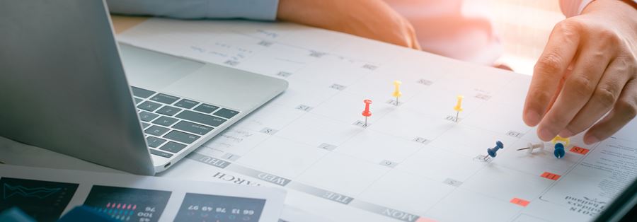 A man witch his computer checking his calendar